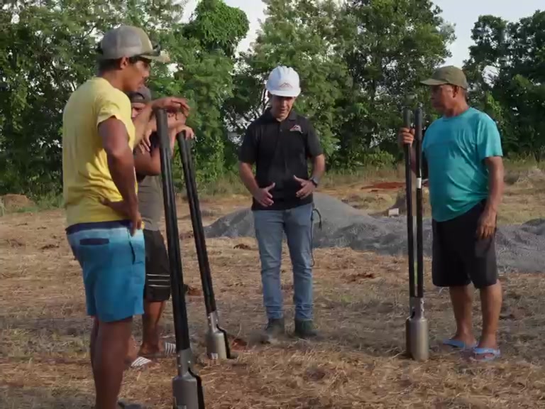 Equipo de obra con ahoyadoras planificando las bases